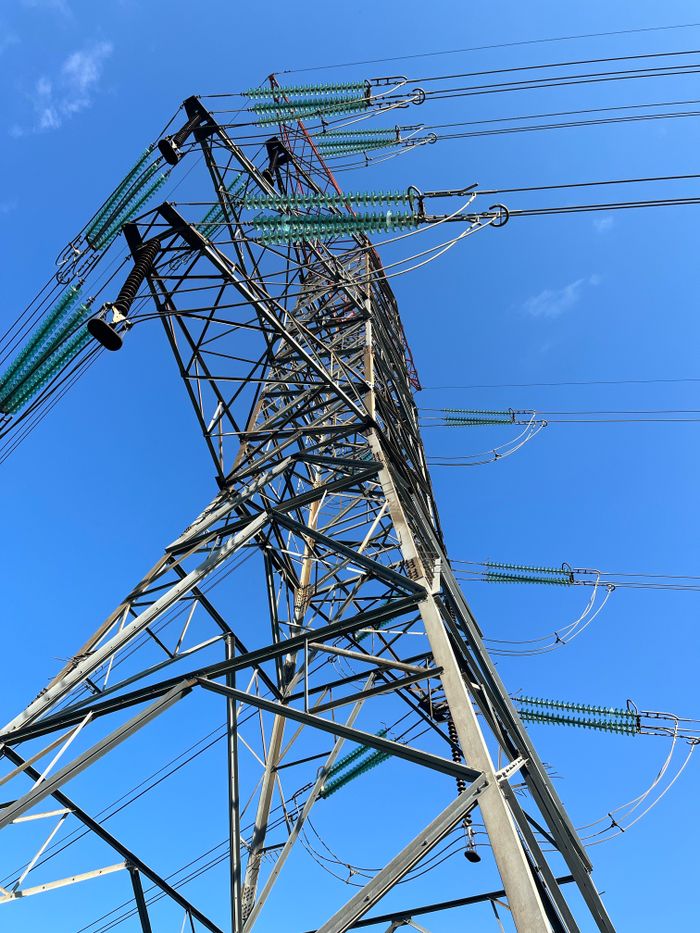 Mastering the First Impression: Your intriguing post title goes here Low-angle view of an electric tower with power lines against a bright blue sky.
